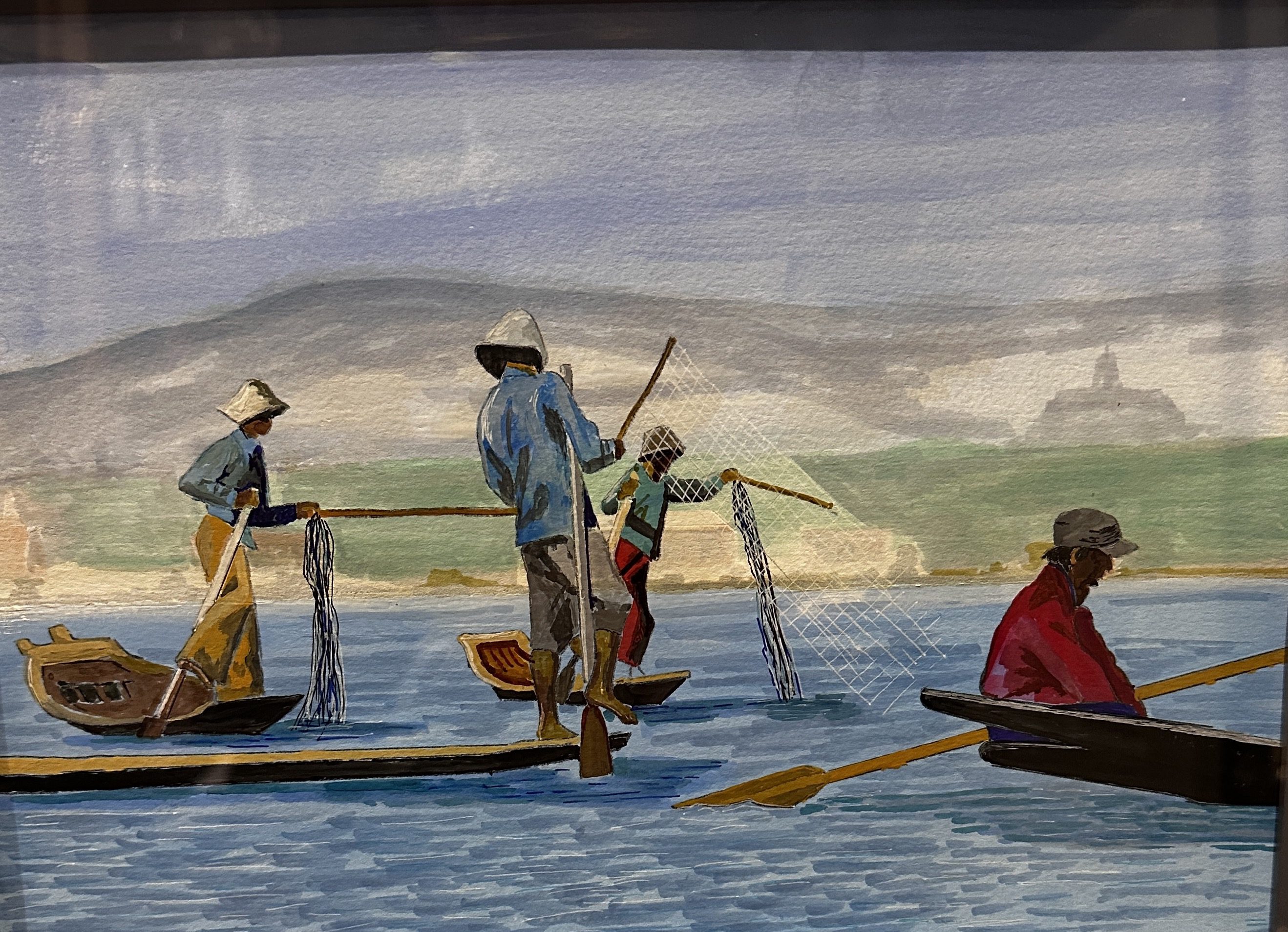 People in traditional clothing rowing boats on a calm river.