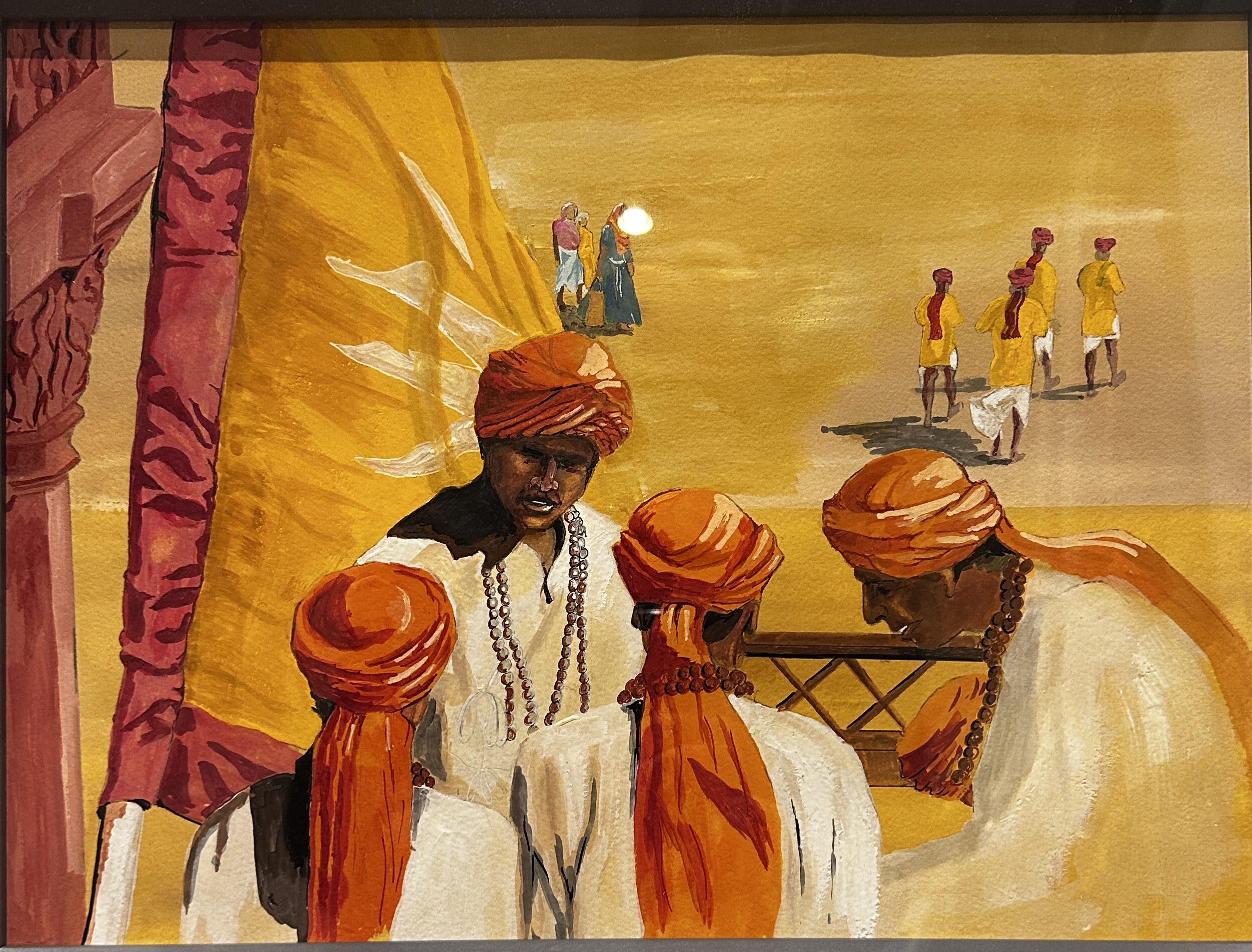A group of men in traditional attire gathered around a table with candles.