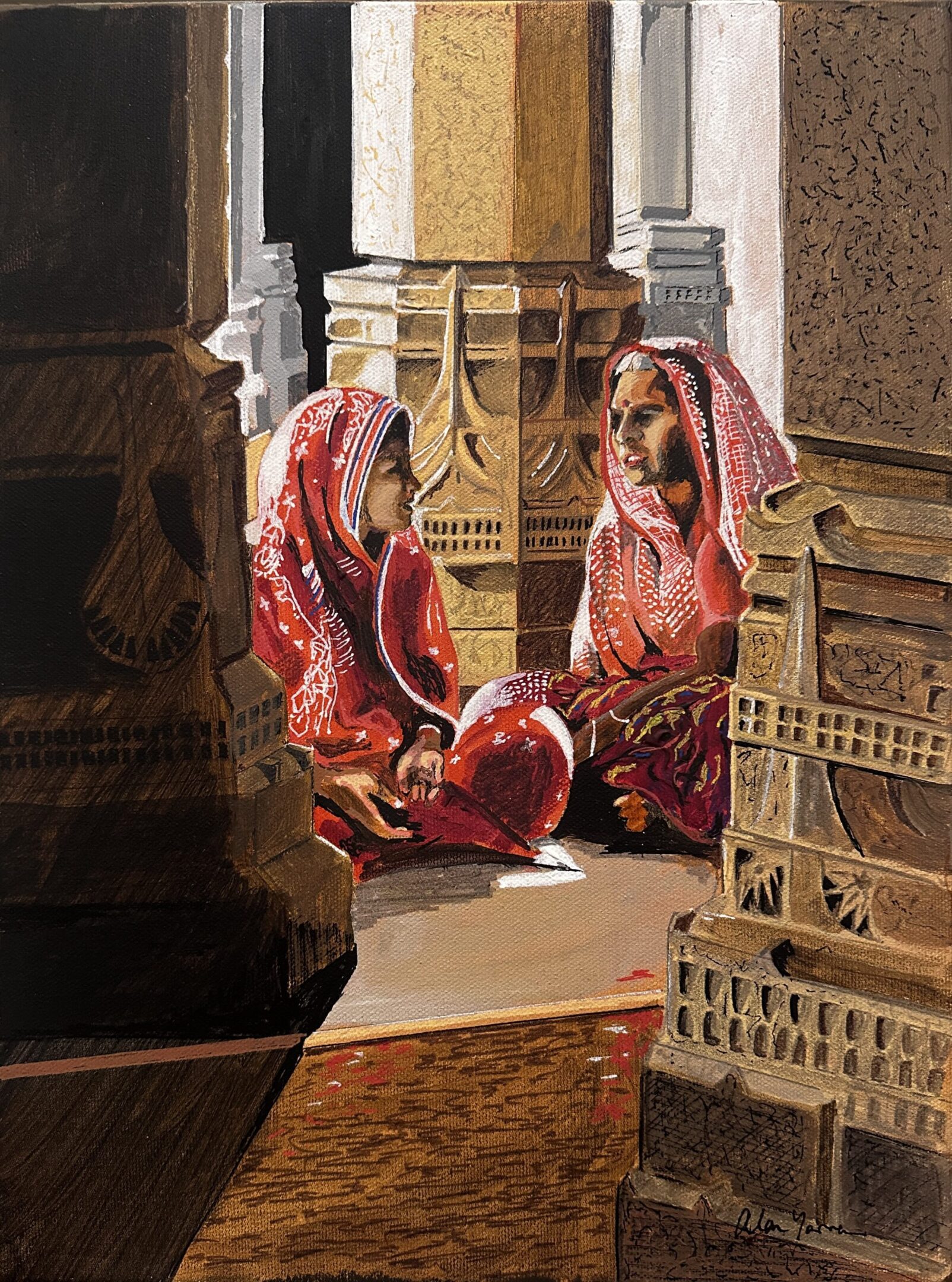 Two women in traditional attire sit inside a temple, engaged in conversation.