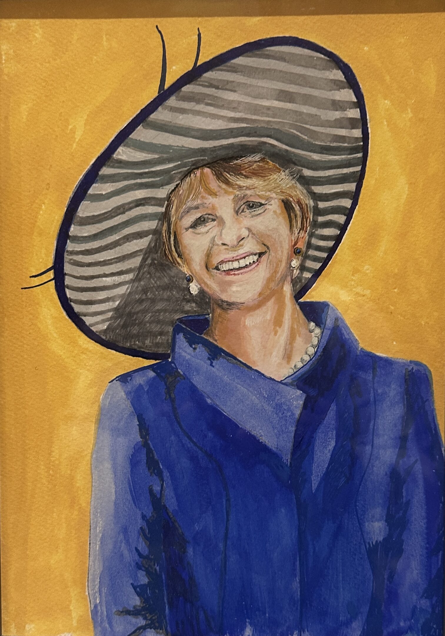 A smiling woman in a large striped hat and blue outfit.