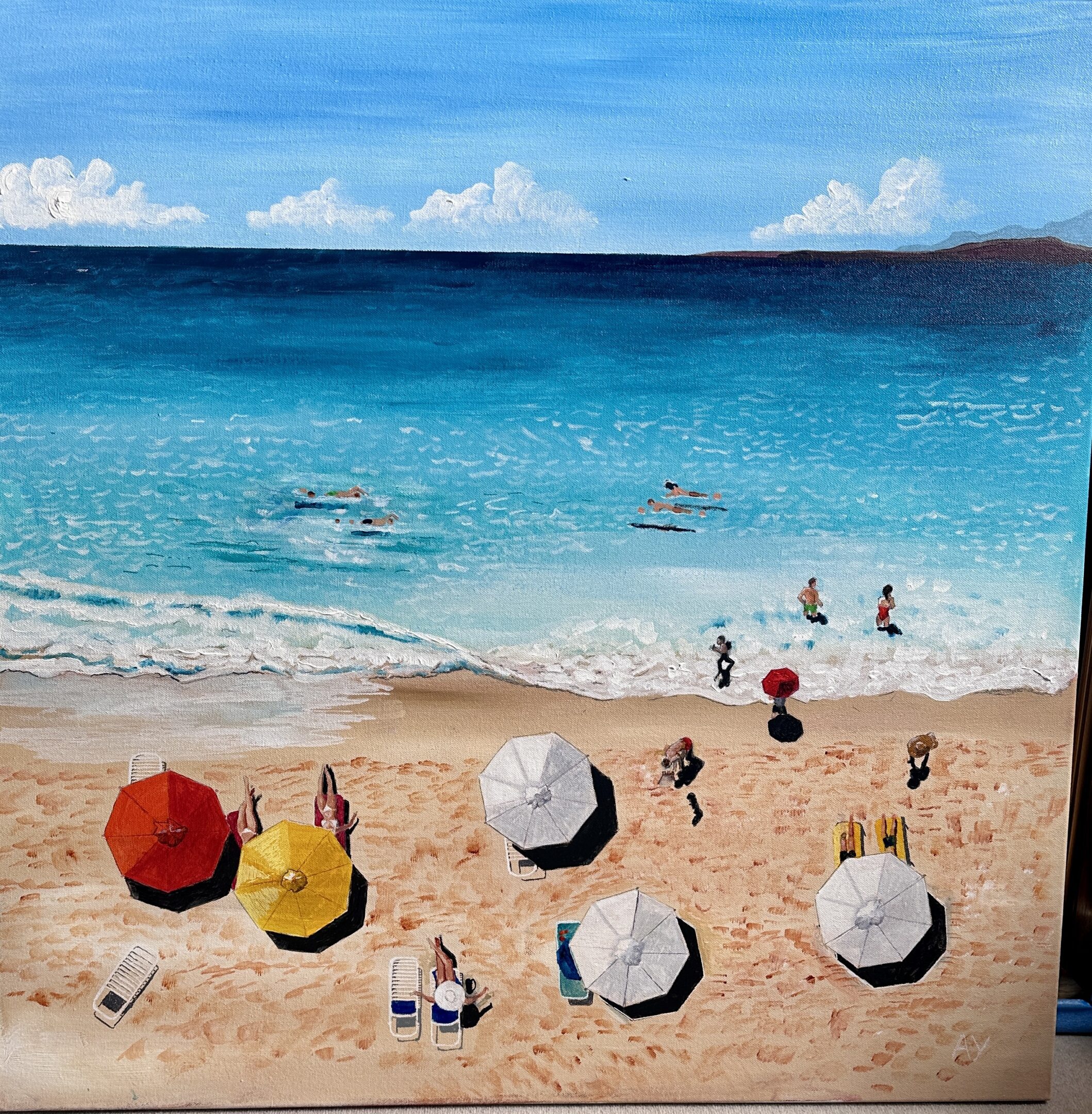 Colorful umbrellas on a sandy beach with people in the water.