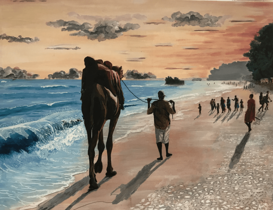People walking with camels along a beach at sunset.