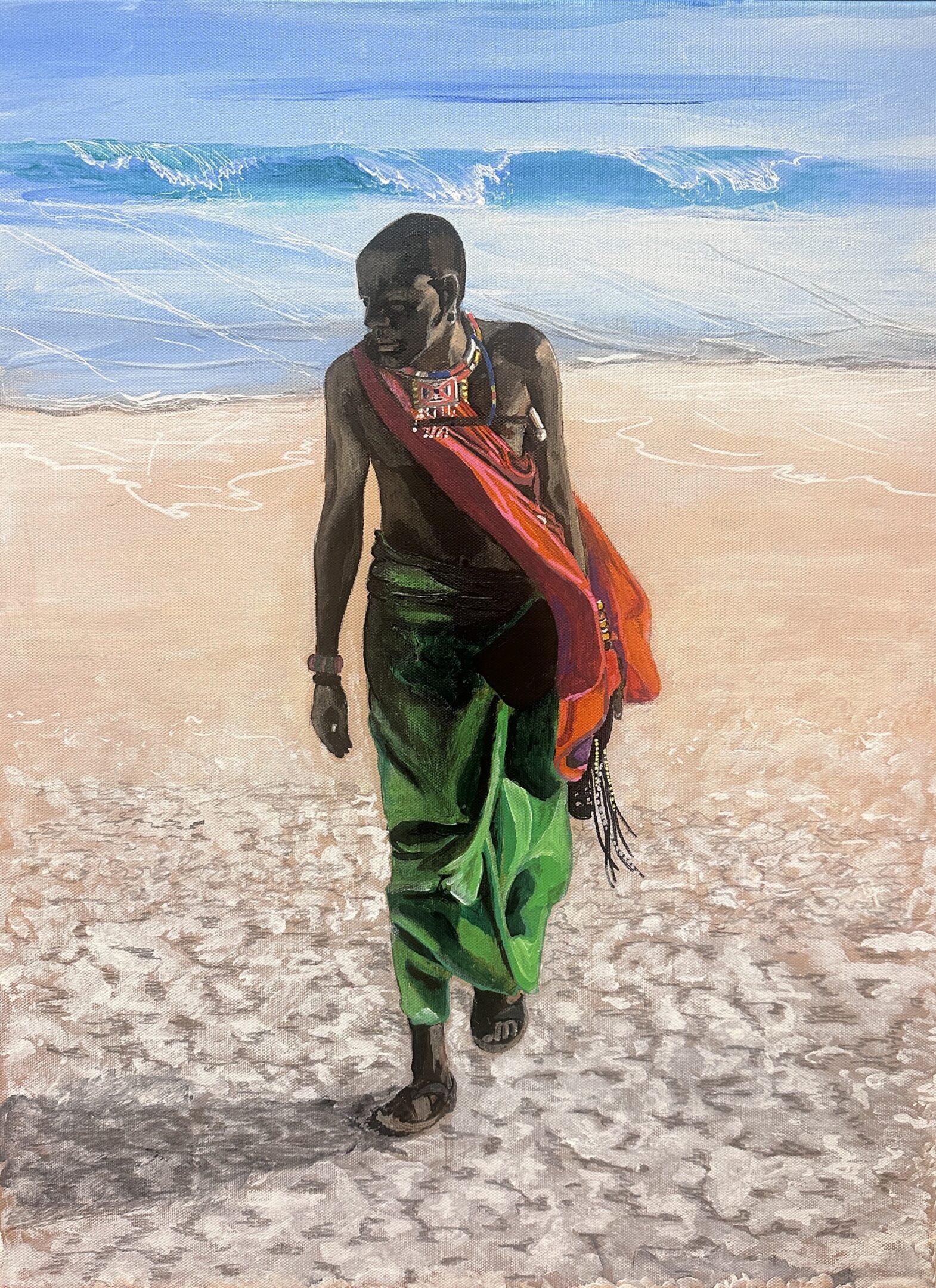 Man walking on beach carrying a red bag.